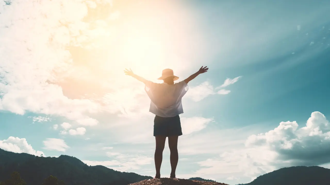 Image of woman on mountain top before sunrise